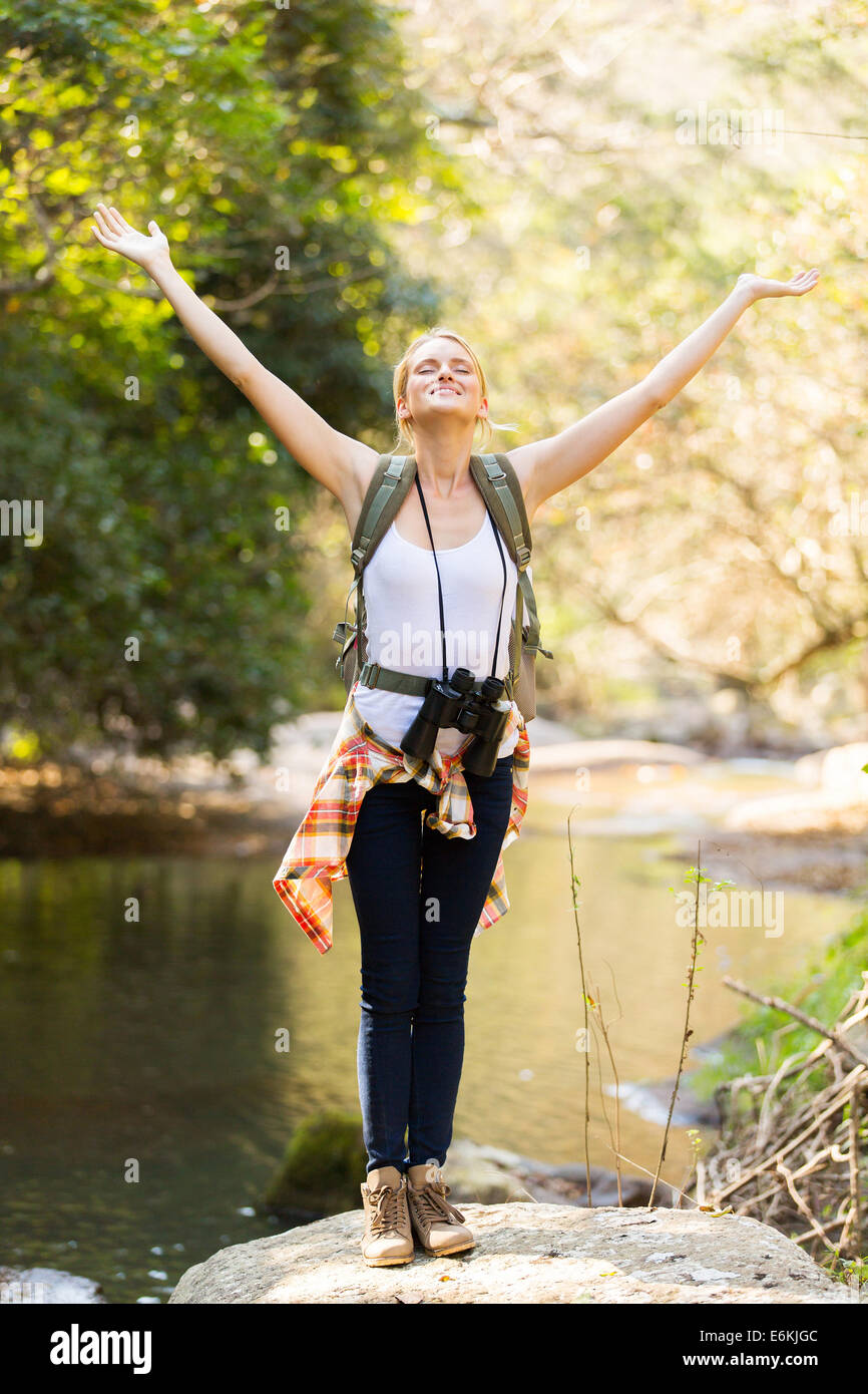 Felice giovane femmina escursionista bracci aperti in valle di montagna Foto Stock
