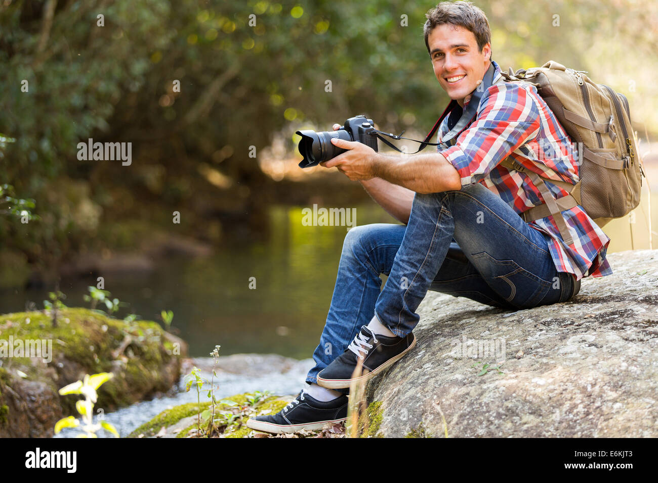 Bel giovane fotografo di riposo in valle di montagna Foto Stock