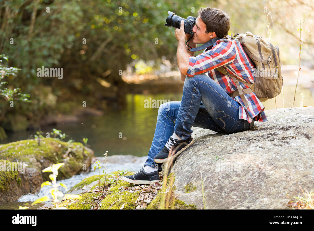 Giovane fotografo fotografare in valle di montagna Foto Stock