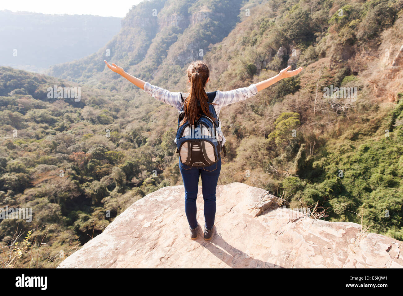 Giovane donna escursionista bracci aperti sulla scogliera di montagna Foto Stock