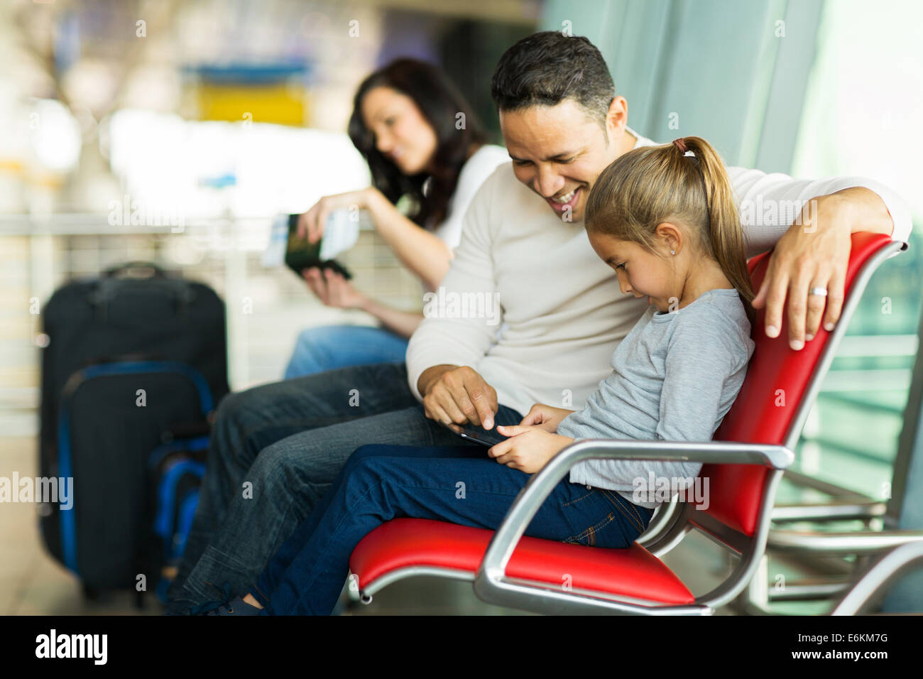 Felice padre e figlia utilizzando computer tablet all'aeroporto mentre aspetta per il loro volo Foto Stock