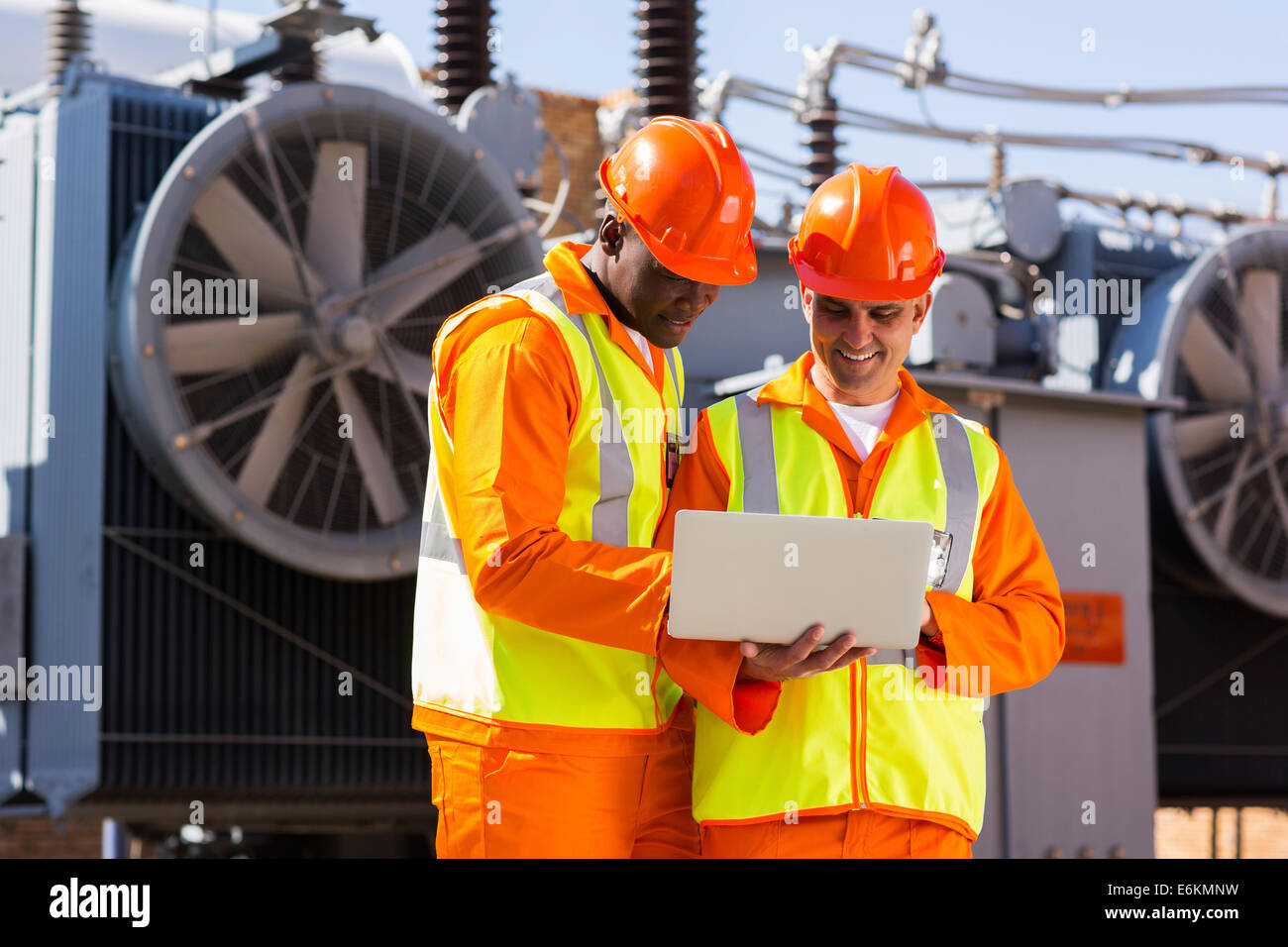 Ingegneri elettrici utilizzando il computer portatile nella sottostazione elettrica Foto Stock
