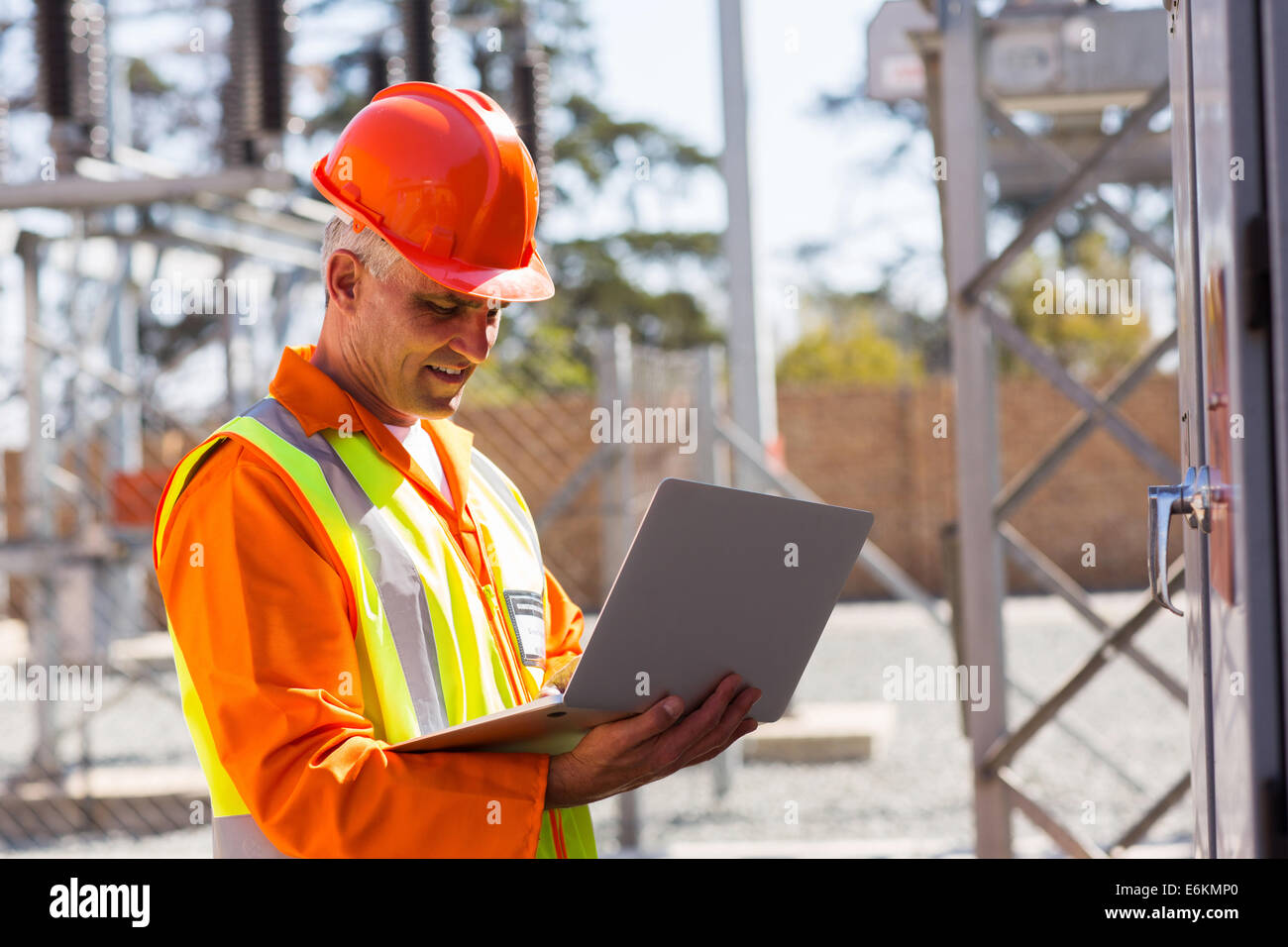 Persone di mezza età engineer utilizzando laptop nella sottostazione elettrica Foto Stock