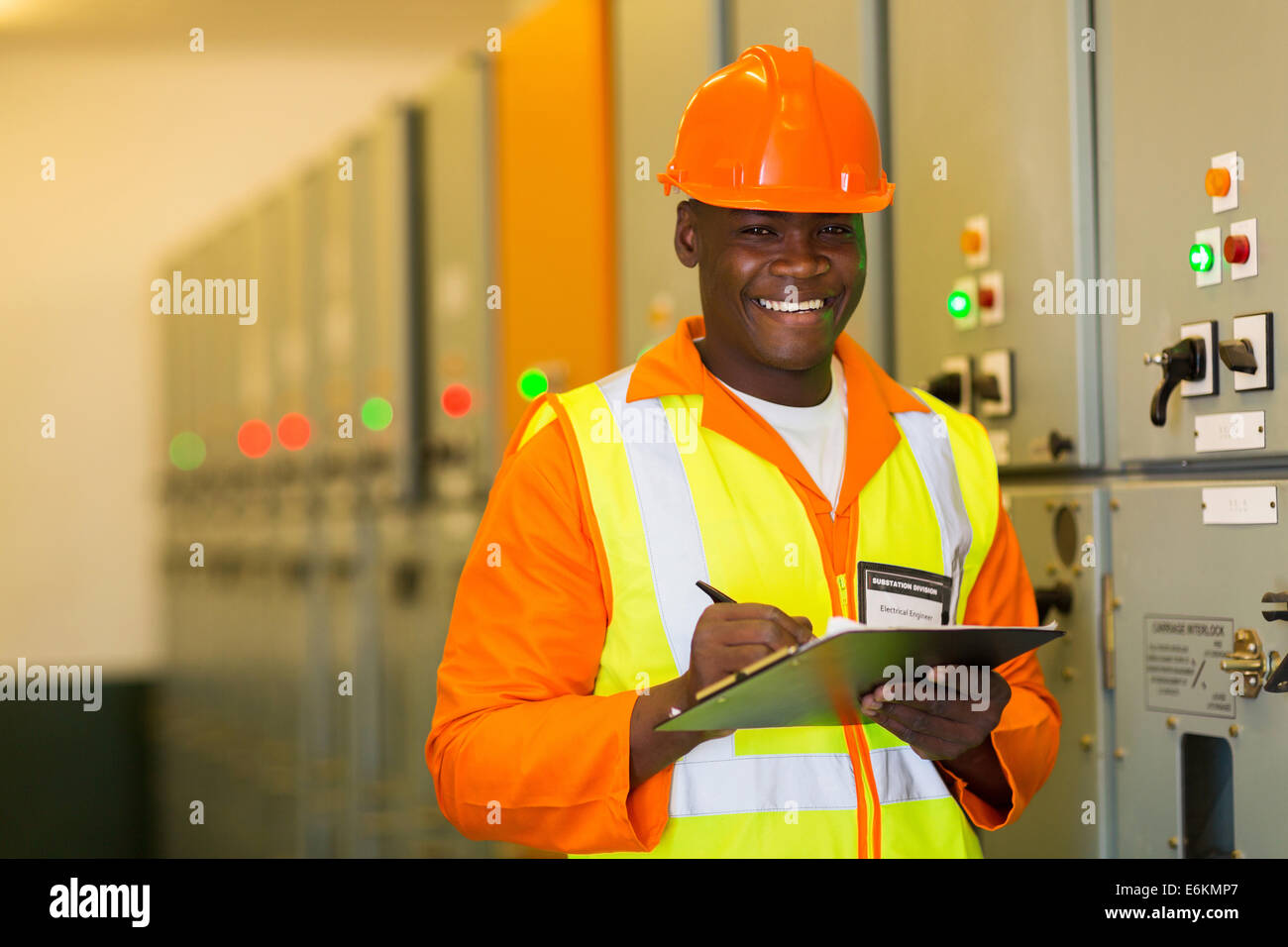 Felice African American engineer in piedi nella parte anteriore del pannello di controllo Foto Stock