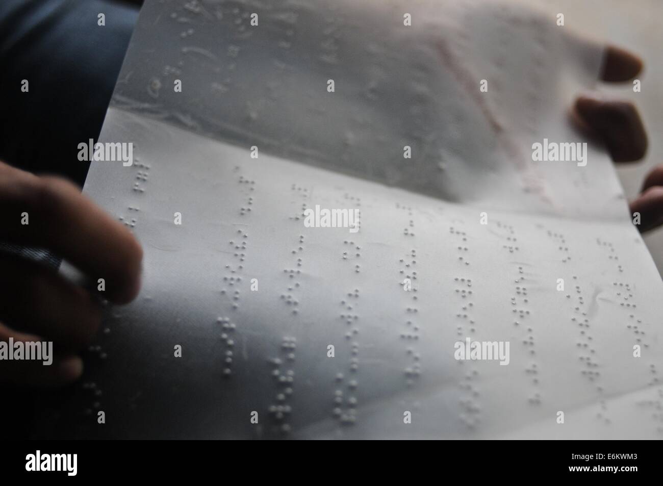 Uomo cieco dalla lettura di una pagina scritta in Braille Foto Stock