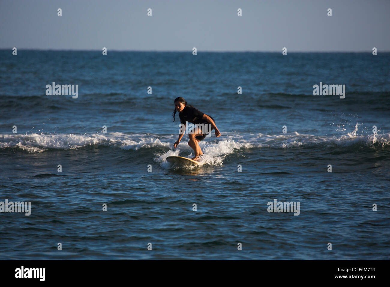 Donna sulla tavola da surf Foto Stock