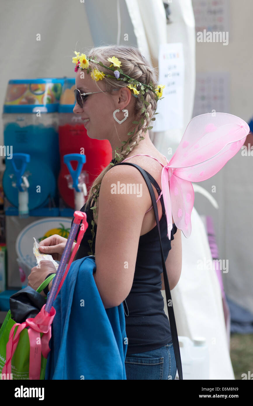 Una giovane donna con ali d'angelo code per una bevanda fredda al vittorioso festival 2014 southsea England Regno Unito Foto Stock