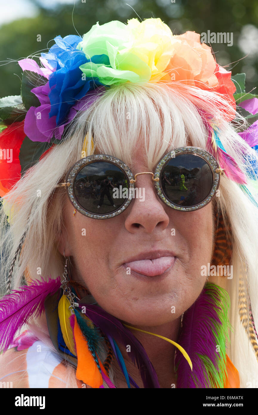 Donna con fiori colorati nei suoi capelli bastoni fuori la sua lingua alla vittoriosa festival 2014 southsea England Regno Unito Foto Stock