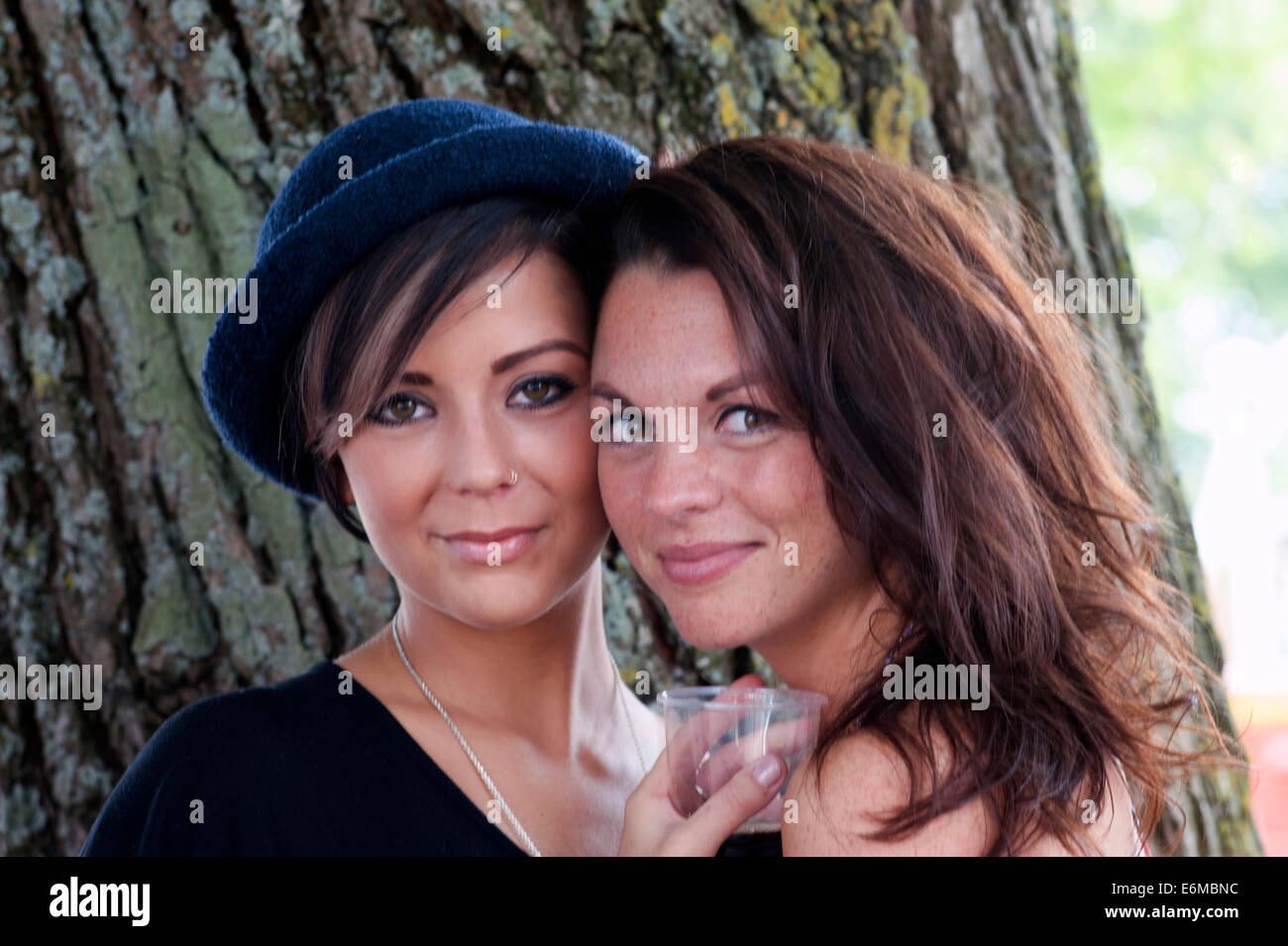 Due belle giovani donne che condividono un drink presso il festival di vittoriosa 2014 southsea England Regno Unito Foto Stock