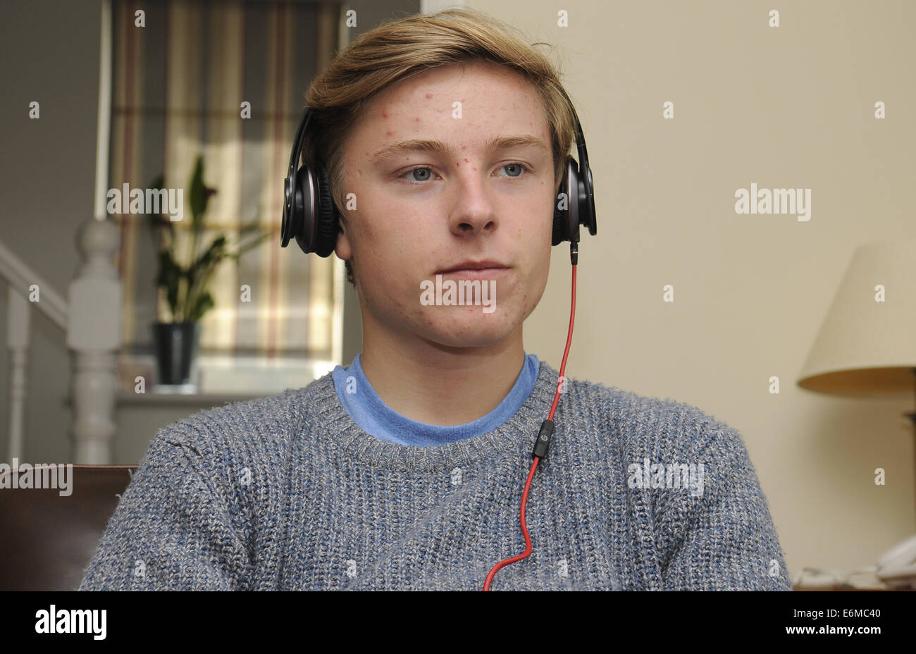 Ragazzo adolescente l'ascolto di musica con cuffie Beats Foto Stock