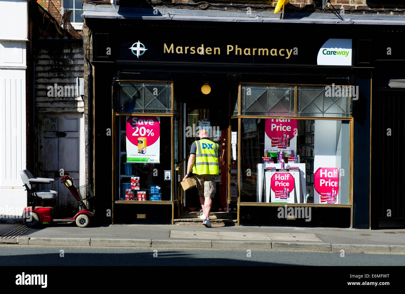 Uomo che cammina in farmacia, Ripon, North Yorkshire, Inghilterra, Regno Unito Foto Stock