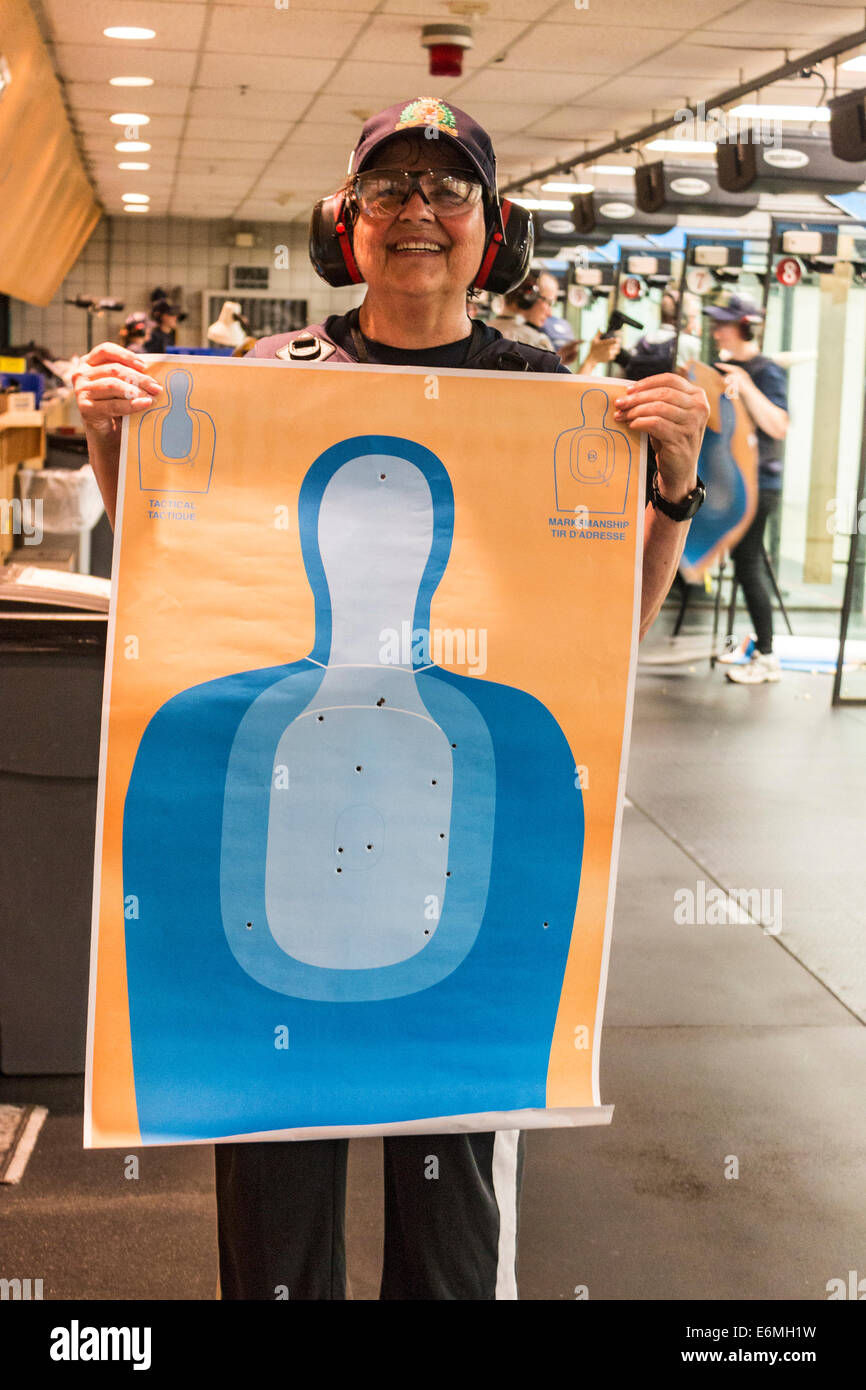 La donna e la sua destinazione dopo imparare a fuoco un 9mm semi automatico pistola. Non è un brutto colpo per un principiante. RCMP Depot academy Foto Stock