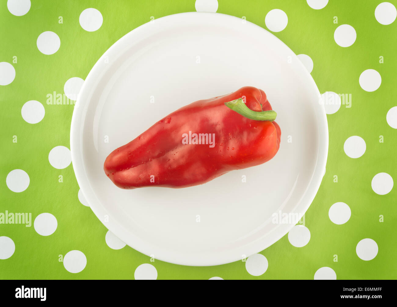 Crudo fresco peperone rosso su una piastra bianca, vista dall'alto. Foto Stock