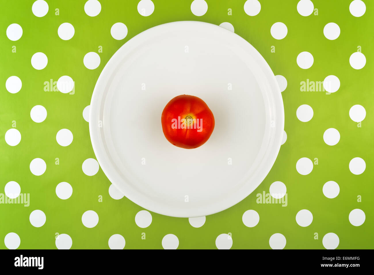 Mangiare crudo fresco di pomodoro rosso su una piastra bianca, vista dall'alto. Foto Stock