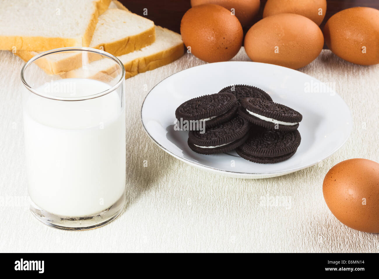 Mangiare sano con latte fresco, biscotti al cioccolato, uova e pane Foto Stock