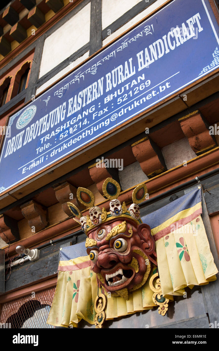 Il Bhutan orientale, Trashigang, mercato superiore, grande ballo intagliato maschera al di sopra di craft shop porta Foto Stock