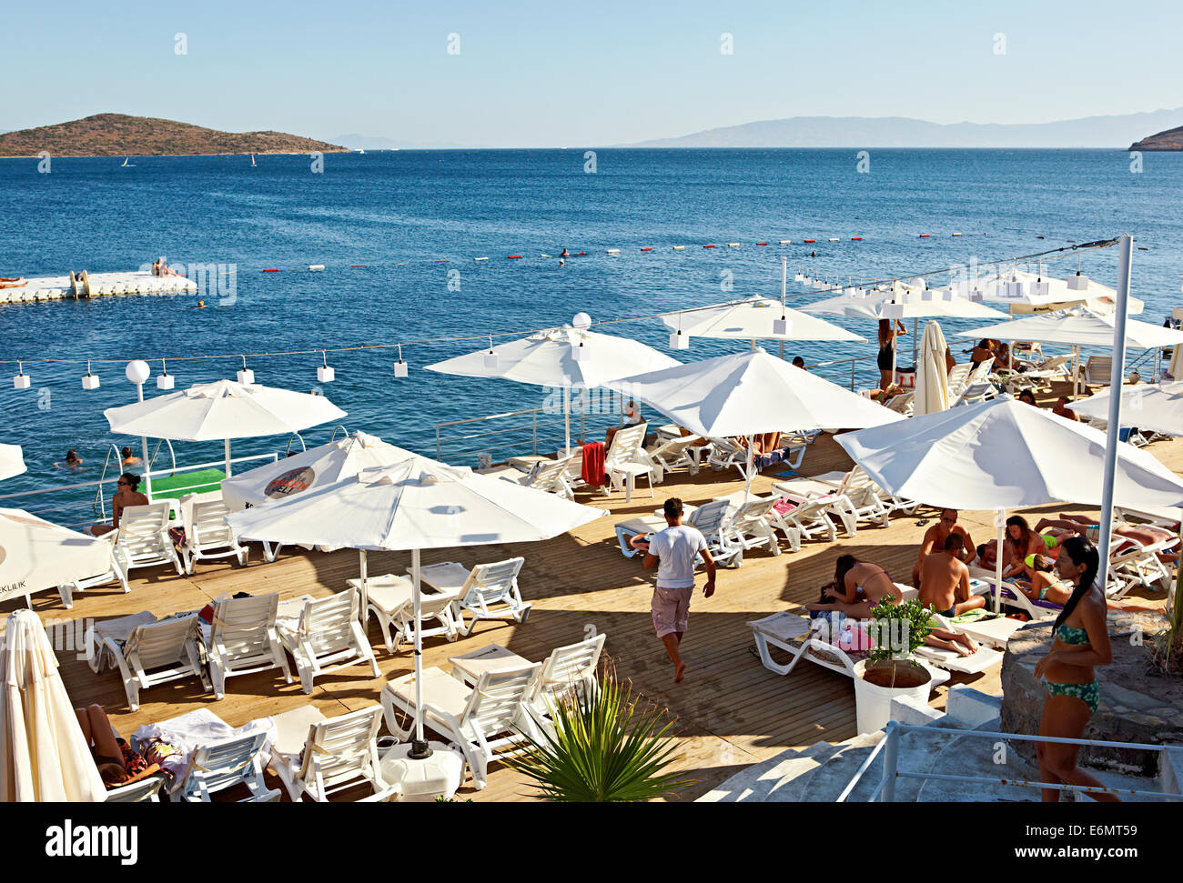 Per vacanza rilassante dal limpido mare blu, a guardare le barche e gustare drinks a Beyaz Beach Club di Bitez Turchia Foto Stock