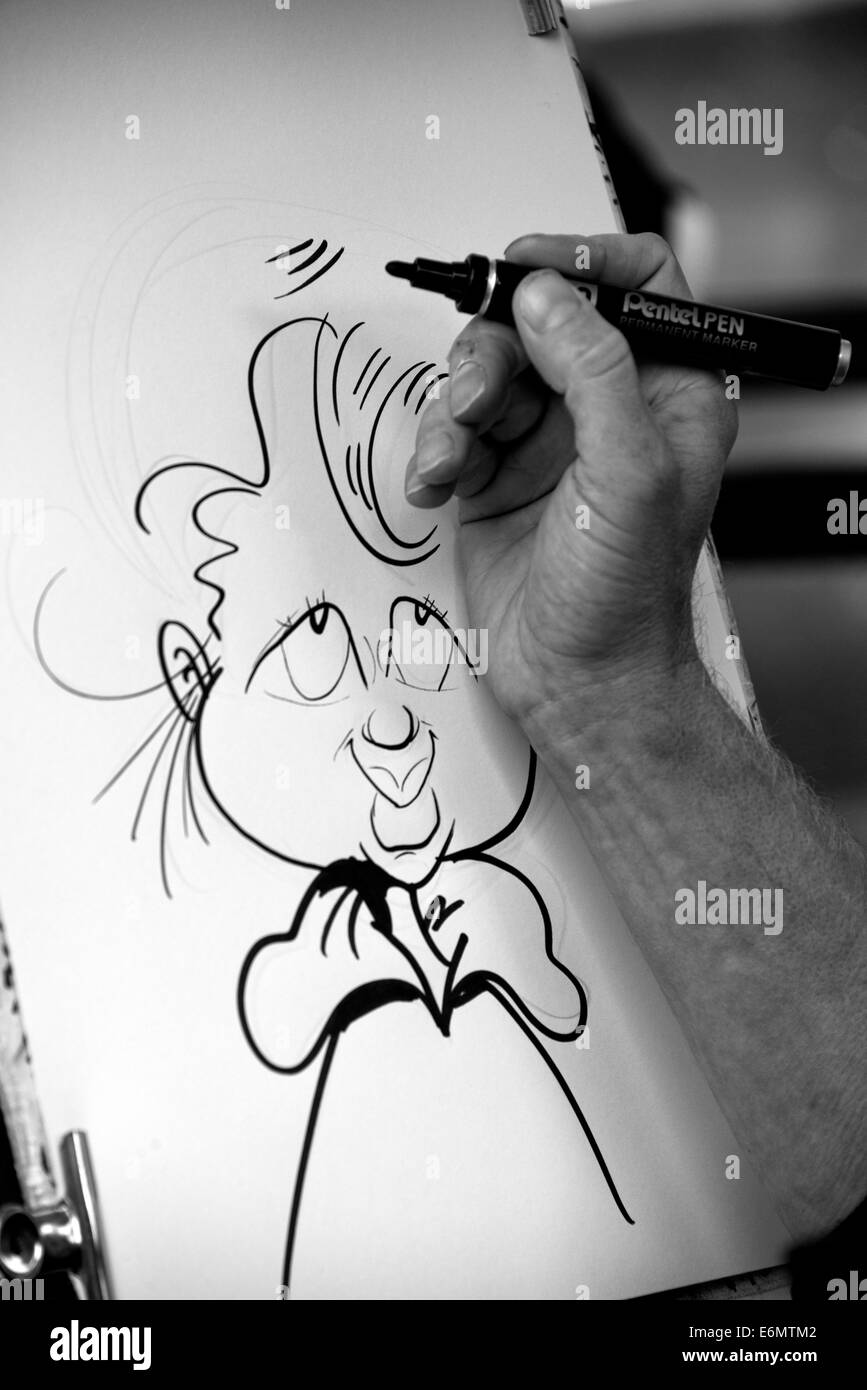 Un artista il disegno di una caricatura sul Royal Mile di Edimburgo. Foto Stock