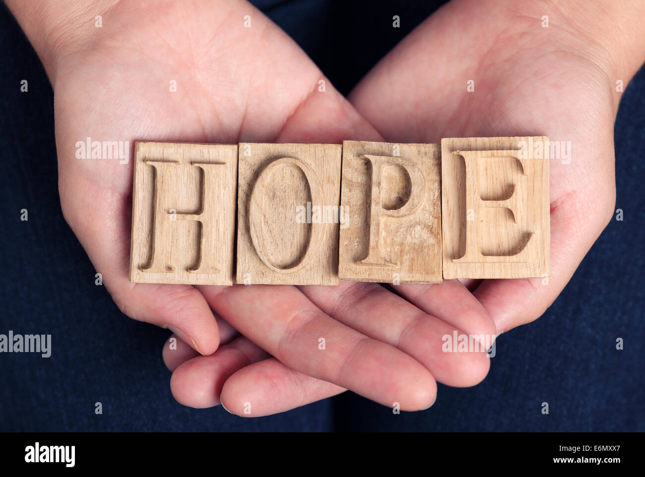 La parola "speranza" enunciato in rilievografia lettere nella donna con le mani in mano. Foto Stock