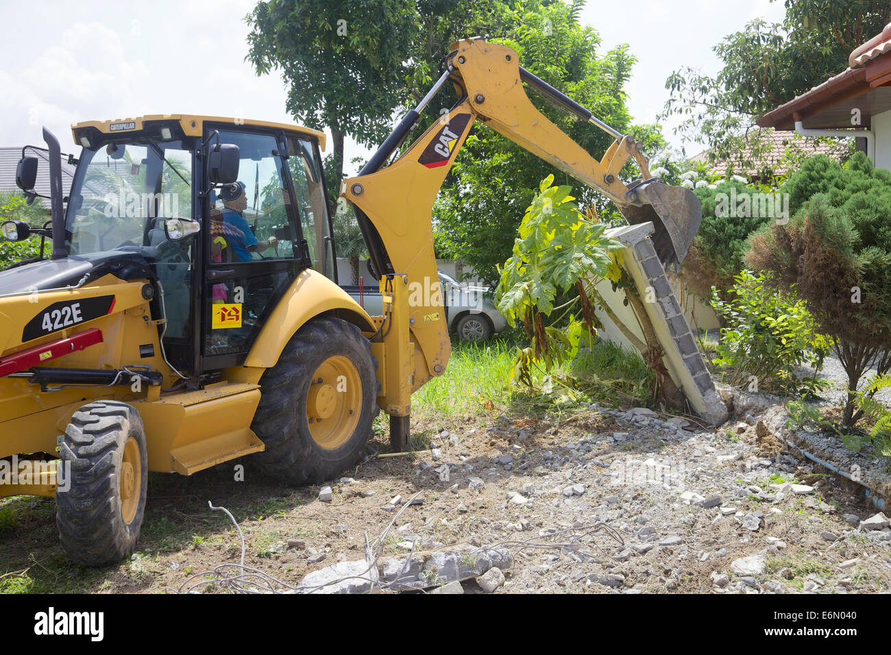 Un gatto digger abbattendo un muro in Phuket, Tailandia Foto Stock