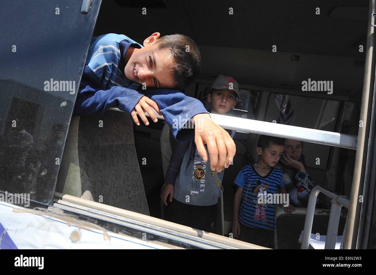 Fishkhabour, Iraq. Il 27 agosto, 2014. I rifugiati continuano a provenire dalla regione di Sinjar attraversando il Tigri sul ponte Fishkhabour. Due autobus dell UNHCR ha portato decine di rifugiati nel nord dell'Iraq dopo la fuga del gruppo di terrore lo Stato islamico. Ci sono bambini e anziani sul bus rendendo le 6 ore di viaggio in 140 gradi temperature. Credito: Gail Orenstein/ZUMA filo/Alamy Live News Foto Stock