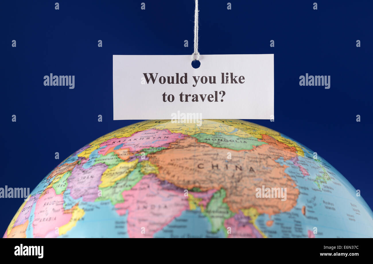 Pezzo di carta con il testo "vuoi viaggiare?' oltre il globo. Foto Stock