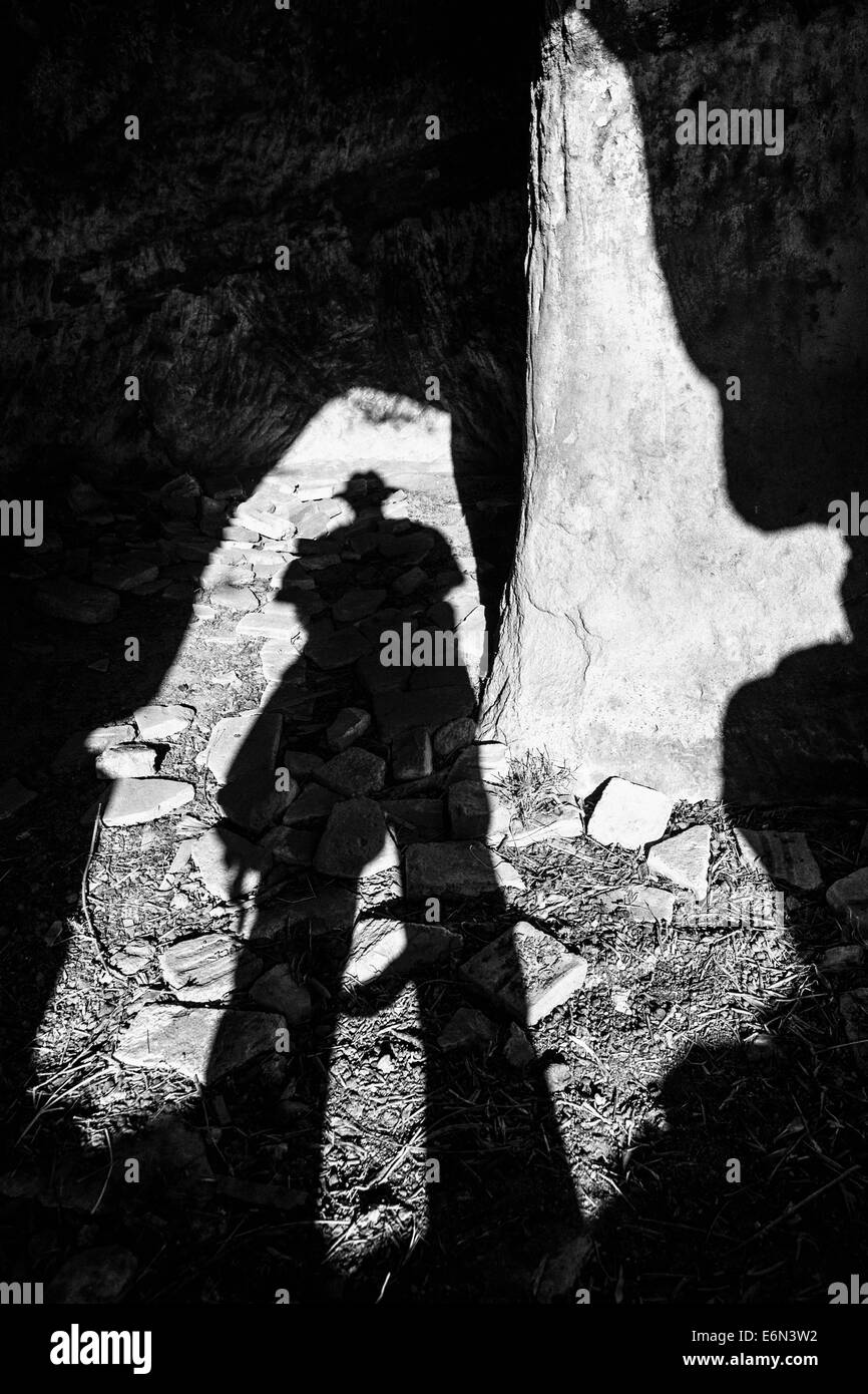 Ombra di un uomo entra in una grotta abbandonata chiesa,Brancaleone Vetus, Calabria, Italia. Foto Stock