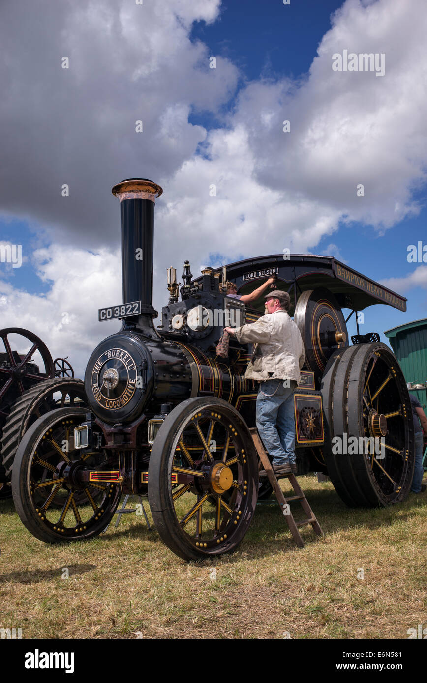 L'uomo la pulizia a vapore motore di trazione ad un vapore inglese fair. Regno Unito Foto Stock