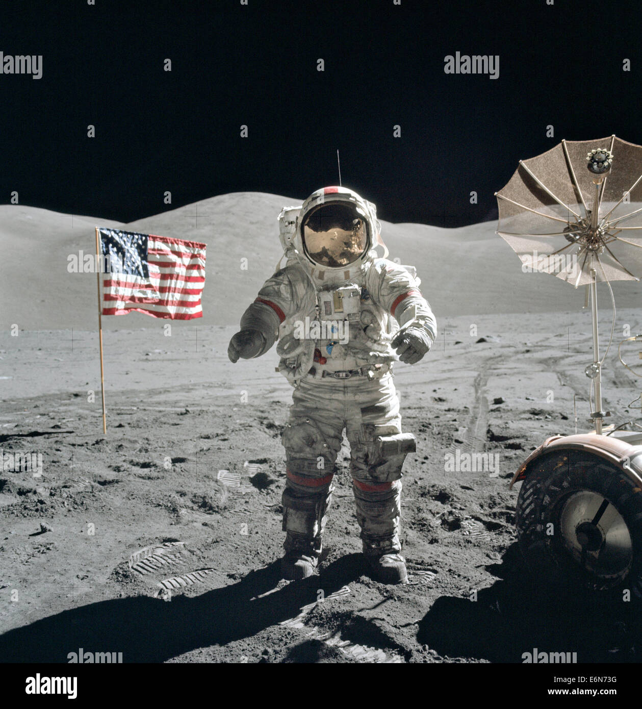 L'astronauta della NASA Eugene Cernan, Commander, Apollo 17, affiancato da una bandiera americana e i loro lunar rover a ombrello antenna ad alto guadagno al Taurus-Littrow landing site Dicembre 13, 1972. La prominente colline scolpite giacciono in background mentre Schmitt di riflessione può essere fatta per Cernan del casco. Mentre gli astronauti Cernan e Jack Schmitt scesi in Challenger per esplorare la regione Taurus-Littrow della luna, astronauta Ronald E. Evans, il pilota del modulo di comando, è rimasto con il comando Service Module "America" in lunar-orbita. Foto Stock