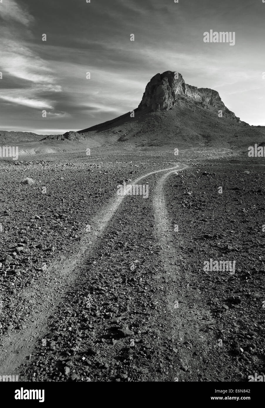 Immagine in bianco e nero di una roccia isolata montagna nel sole caldo deserto pietroso in Marocco, Africa del Nord Foto Stock
