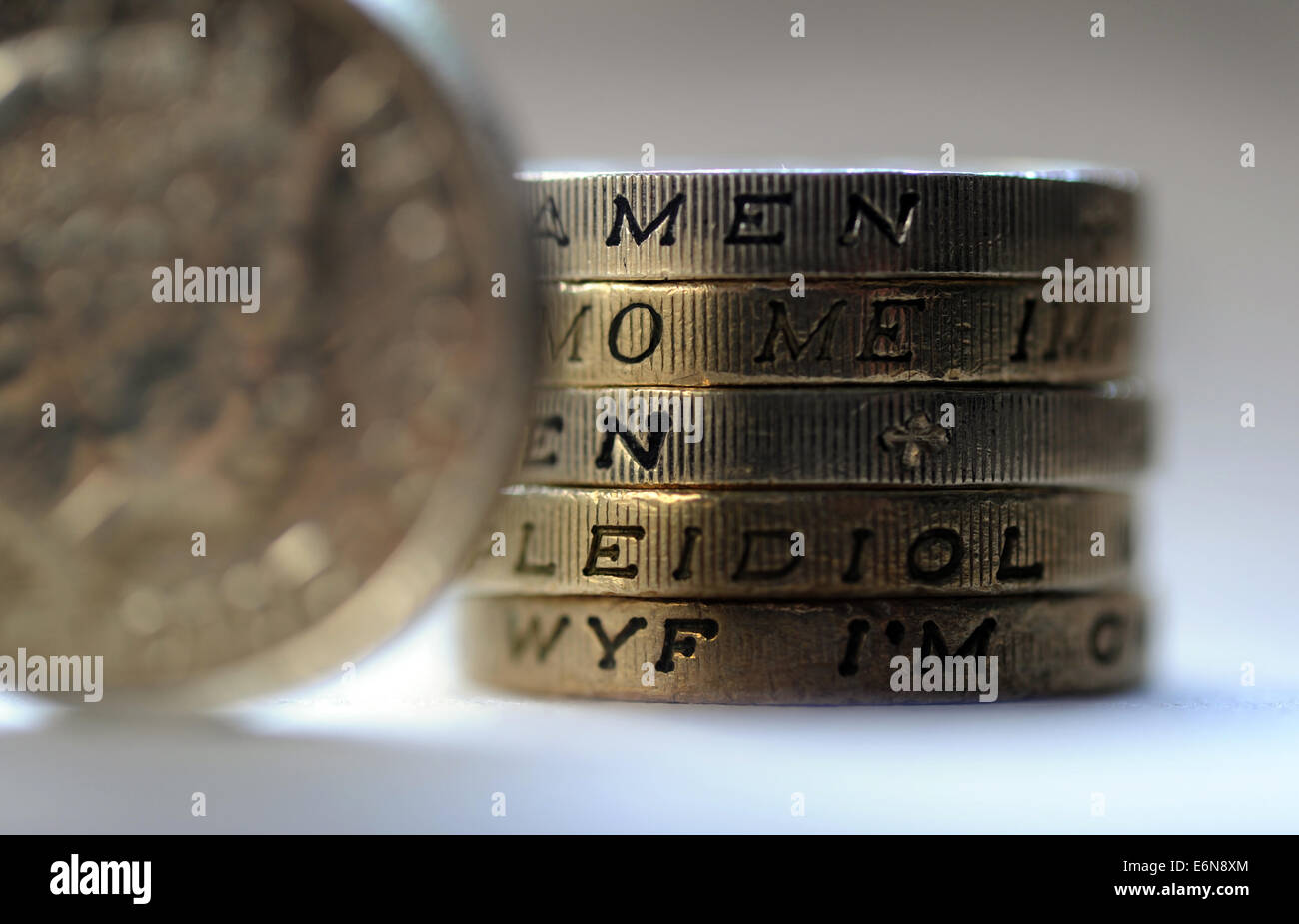 BRITISH una libbra di monete con bordo lettere ortografia 'Strumenti' nuovamente i salari dei redditi valuta Ipoteche budget familiare i risparmi in contanti UK Foto Stock
