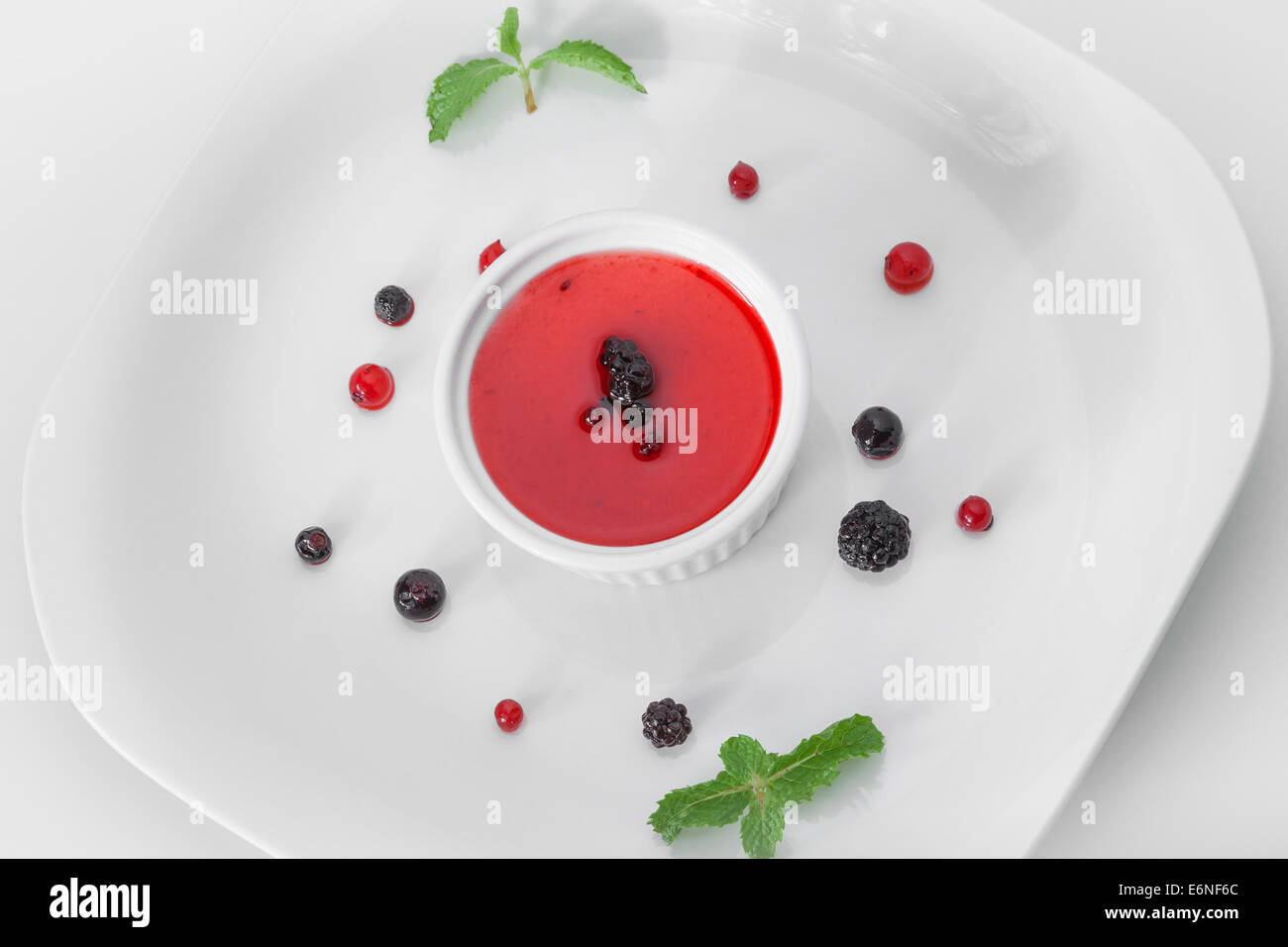 Panna cotta, con blackberry topping di frutta con red corrente, mirtillo Frutta e menta guarnire Foto Stock