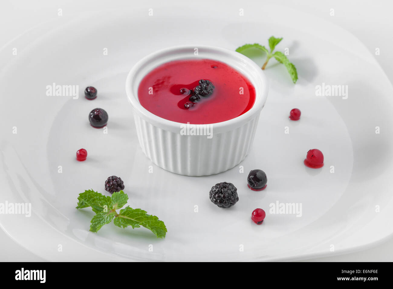 Panna cotta, con blackberry topping di frutta con red corrente, mirtillo Frutta e menta guarnire Foto Stock
