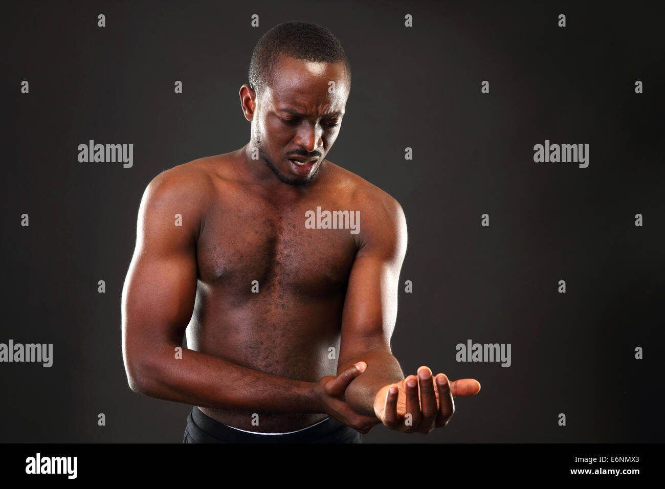 L'uomo africano impulso di controllo su sfondo nero Foto Stock