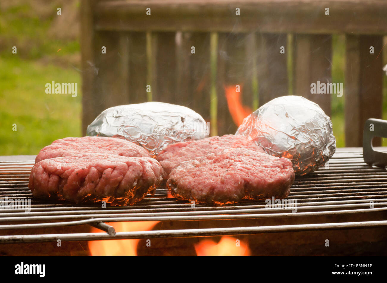 Close-up di Hamburger cottura su un Barbecue Flame-Grilled Foto Stock
