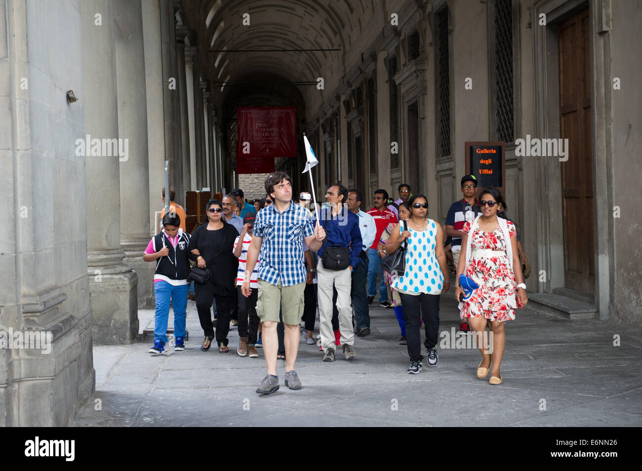 Maschio guida tour con piccola bandiera che mostra tourist intorno al soffitto a volta a piedi modi in Firenze, Italia. Foto Stock