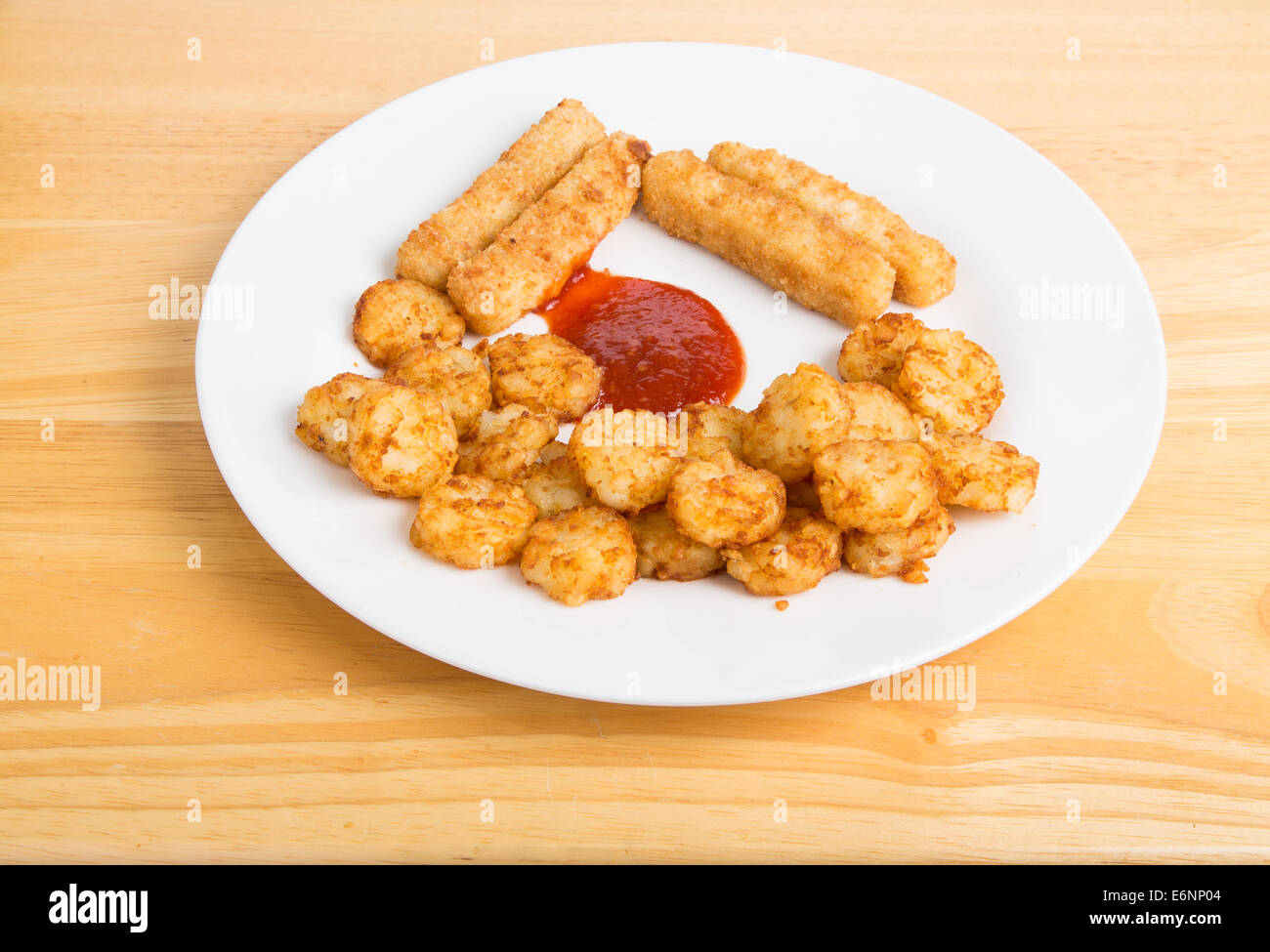 Piastra di colore bianco con il pesce fritto bastoni e sbuffi di patate con salsa cocktail Foto Stock