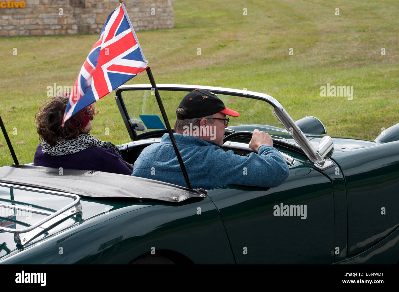 La gente in una Austin Healey Sprite auto su Fosse Way road, Warwickshire, Regno Unito Foto Stock