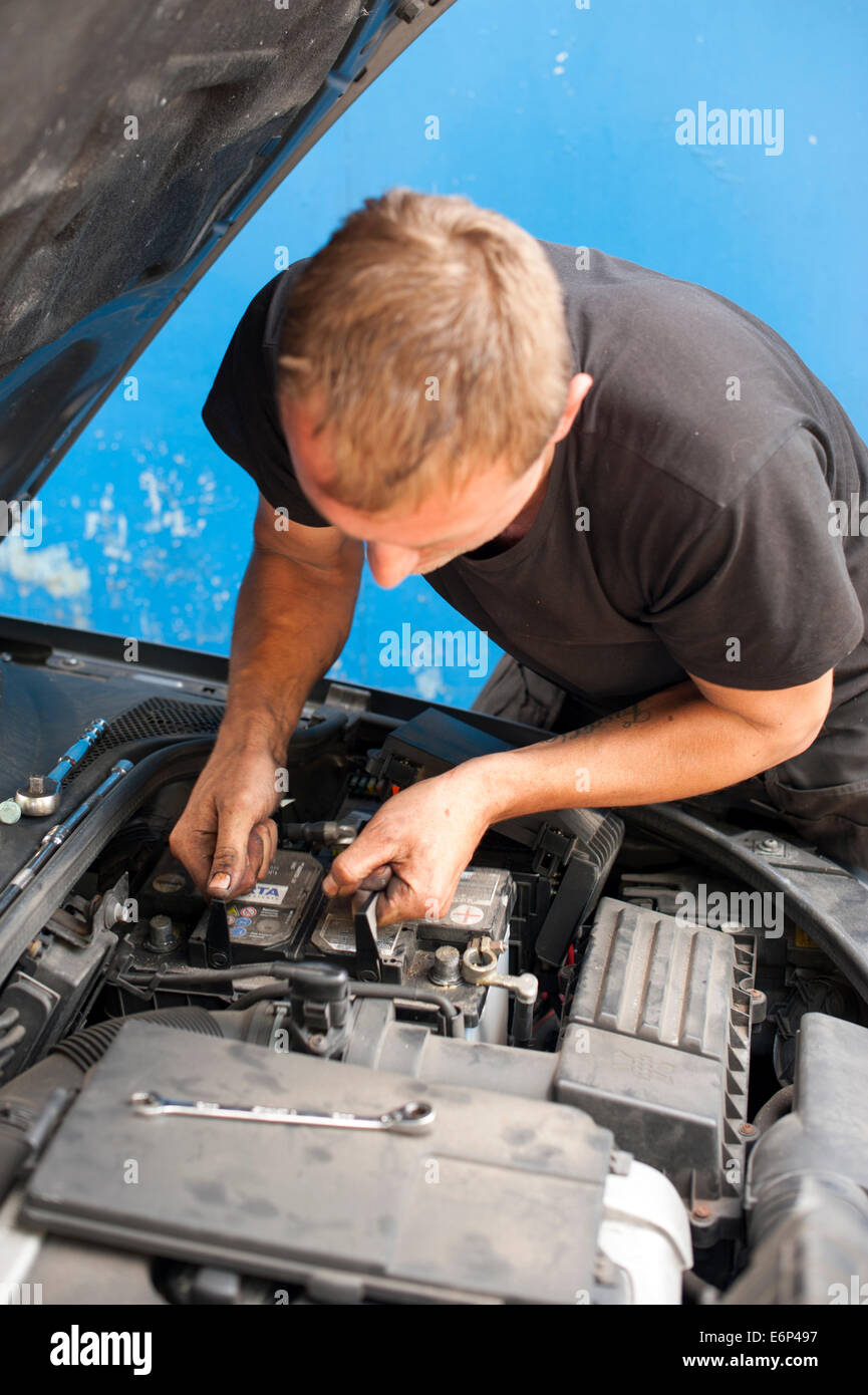 Autofficine rimozione di una vecchia batteria Foto Stock