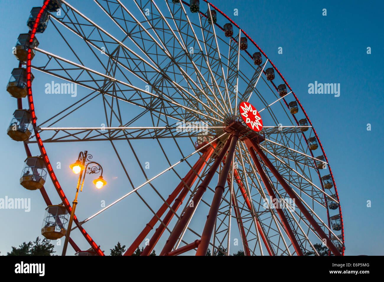 Bella ruota panoramica Ferris in tarda serata con belle luci in un parco Foto Stock