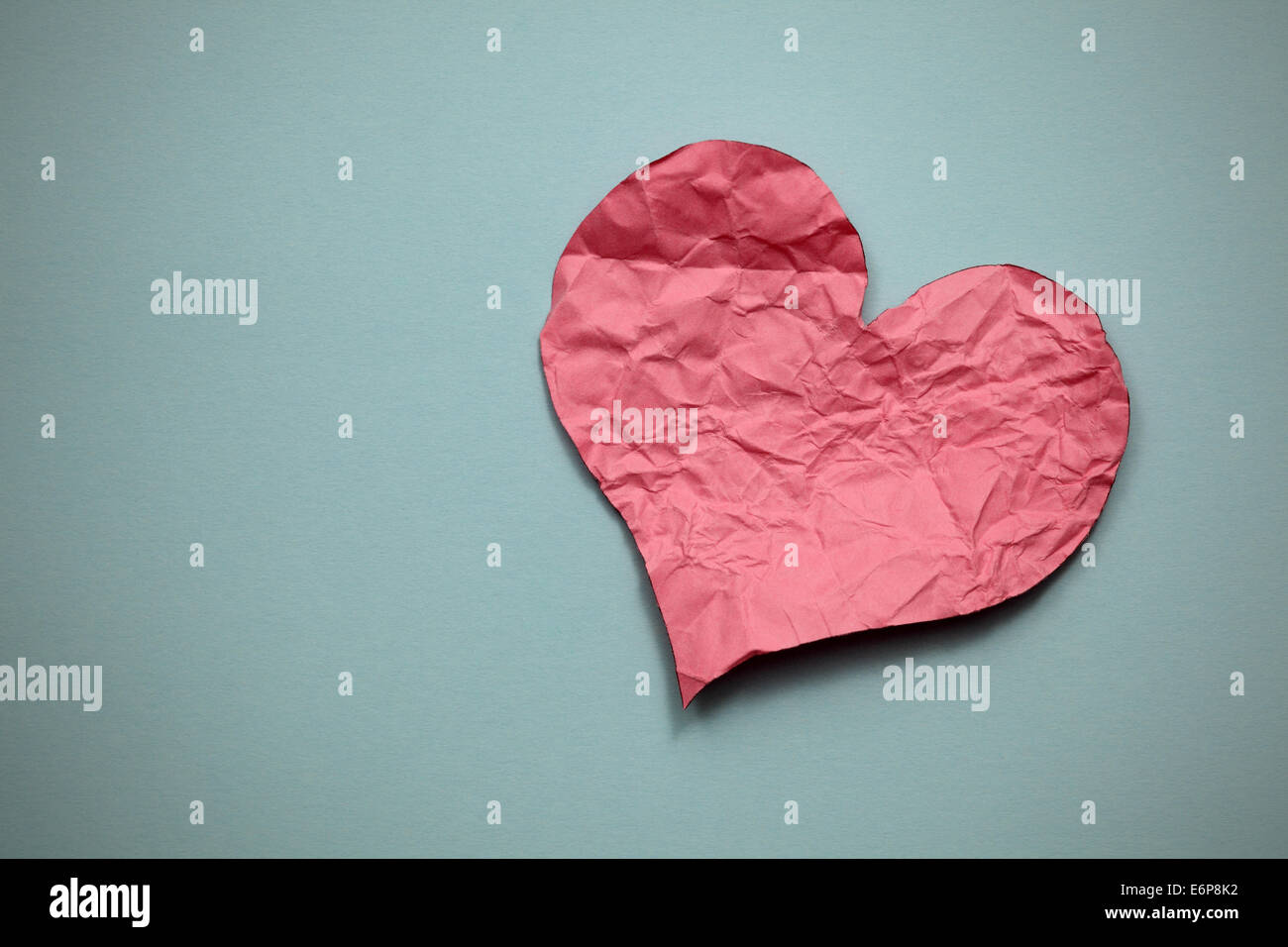 Carta sgualcita cuore su sfondo della carta. Foto Stock