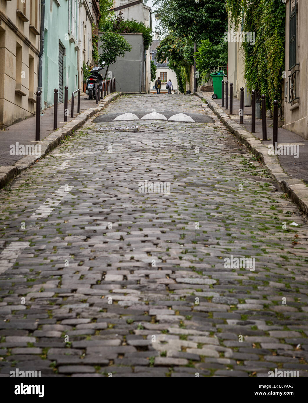Due uomini di raggiungere la sommità di una collina su una pietra ciottoli street in Parigi Francia. Foto Stock
