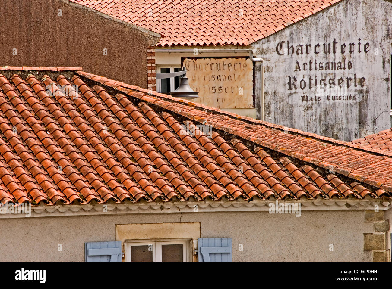Tetti di tegole rosse e vecchie attività di scrittura sulle pareti di un edificio in Vandea città di Talmont St Hilaire in Vandea Foto Stock