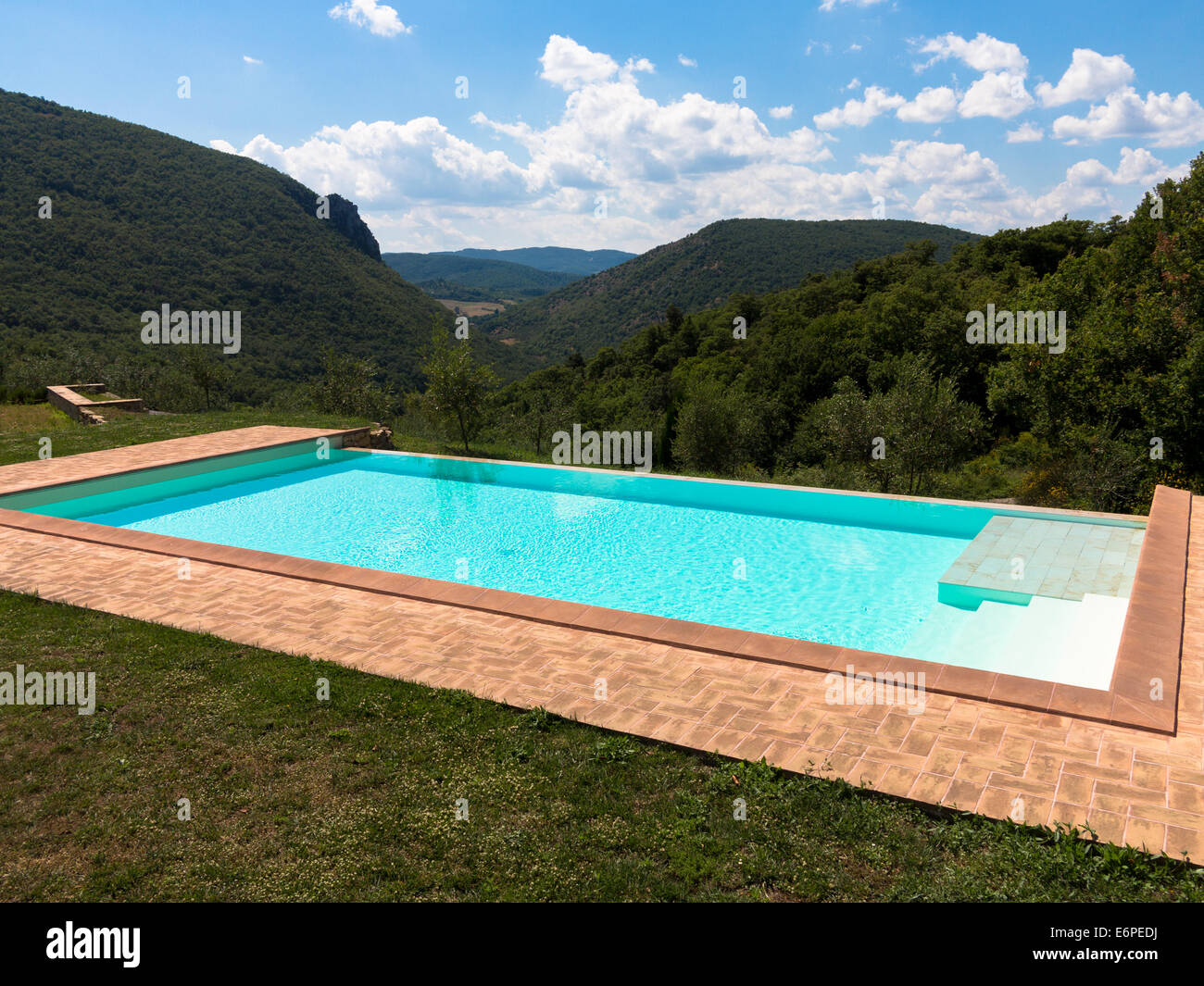 I trend con orizzonte di riferimento e riflessioni in una piscina infinity contro un luminoso cielo del pomeriggio Foto Stock