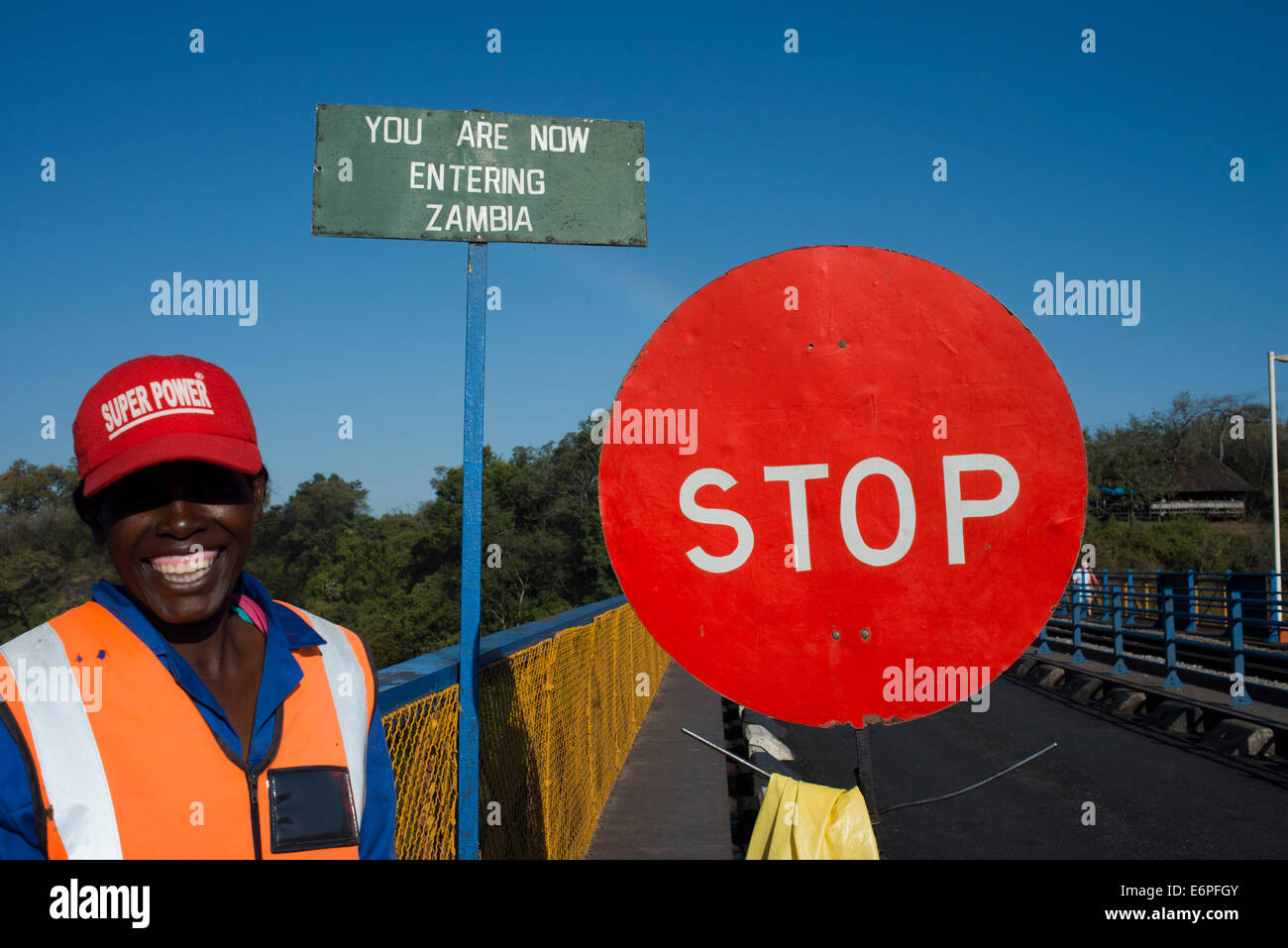 Una donna controlla il traffico tra Zambia e Zimbabwe. Un simbolo di arresto indica che stiamo entrando in Zambia. Oggi uno dei V Foto Stock