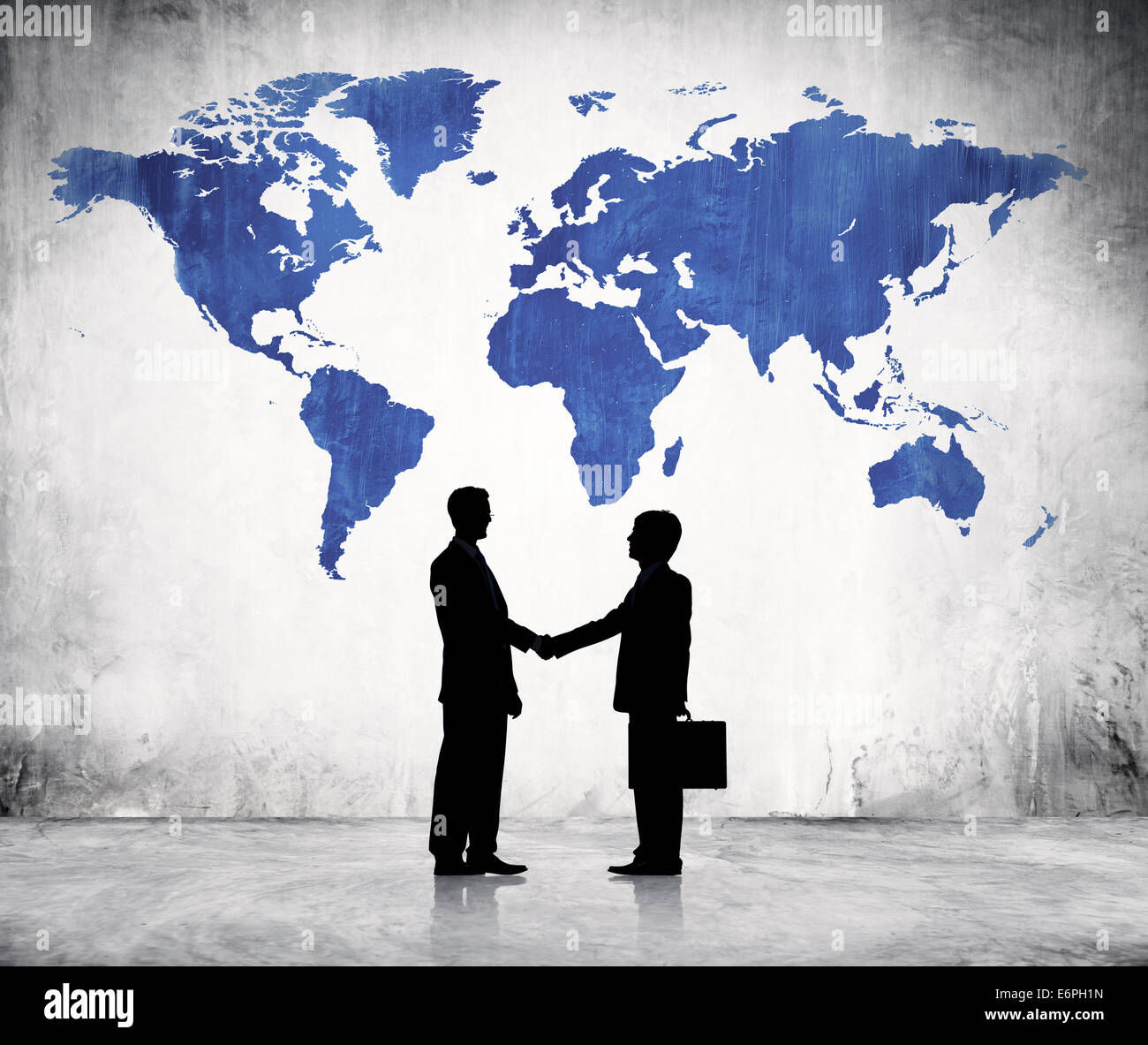 Due uomini di affari si stringono la mano e una cartografia blu del mondo di cui sopra. Foto Stock