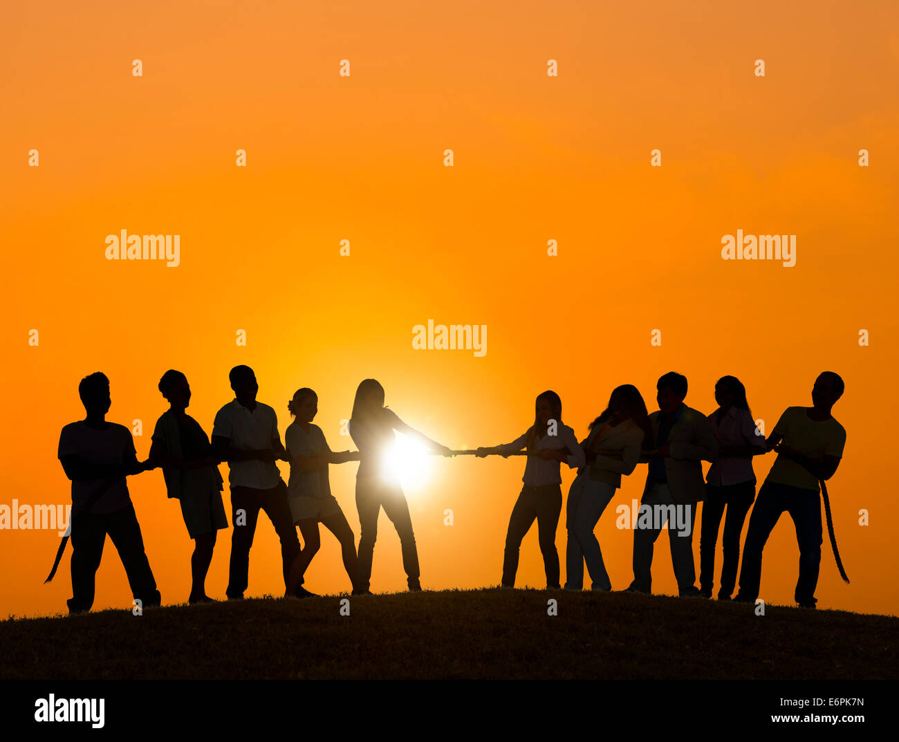 Persone che giocano a tirare o guerre nel retro illuminato Foto Stock