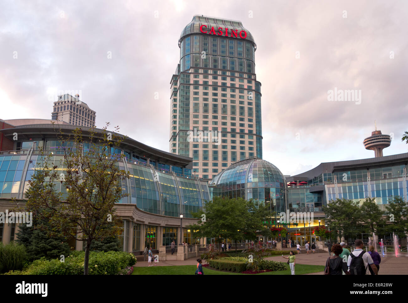 Fallsview Casino Resort in Niagara Falls al tramonto. Le finestre di vetro del centro commerciale per lo shopping e per i turisti a piedi al di fuori. Foto Stock