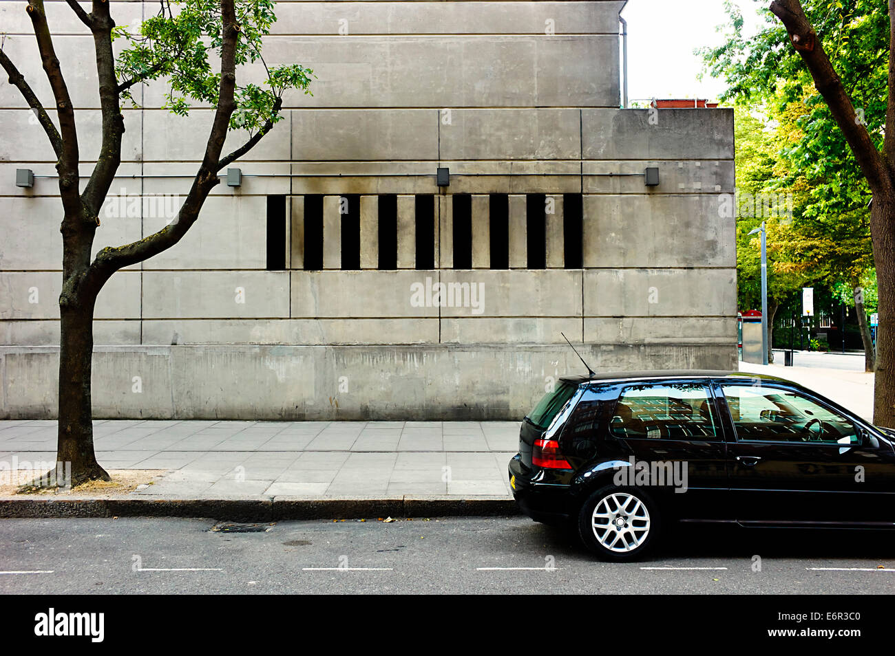 Un edificio di cemento e vetro auto parcheggiata Foto Stock