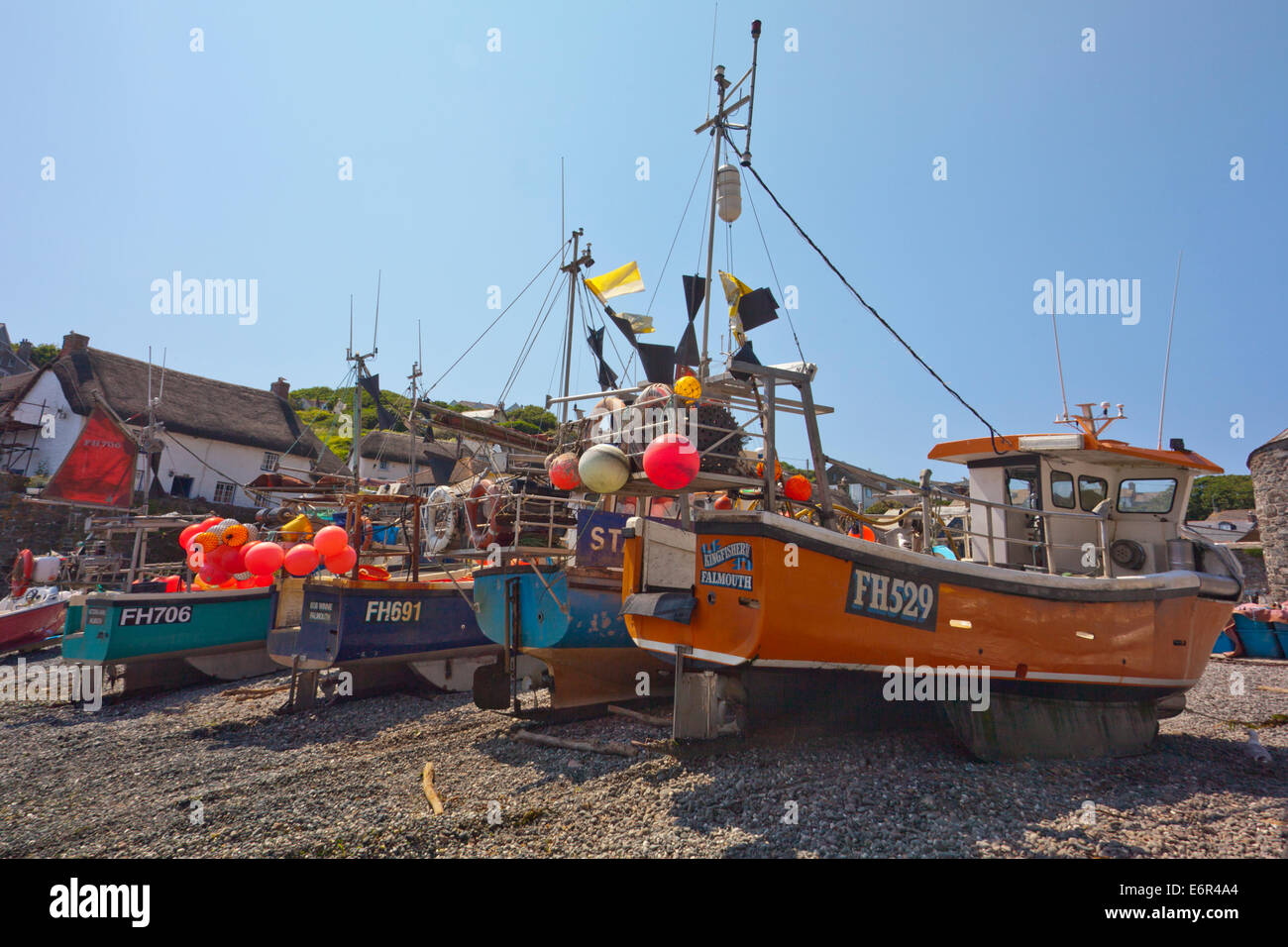 Colorate barche da pesca cazzate fino sulla spiaggia di Cadgwith Cove sulla penisola di Lizard Cornwall Inghilterra REGNO UNITO Foto Stock